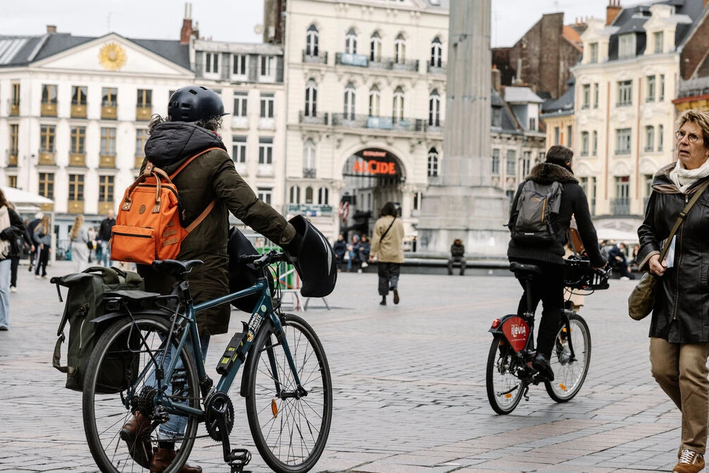 Rue piétonne à Paris avec passants, terrasses de café et immeubles haussmanniens en arrière-plan