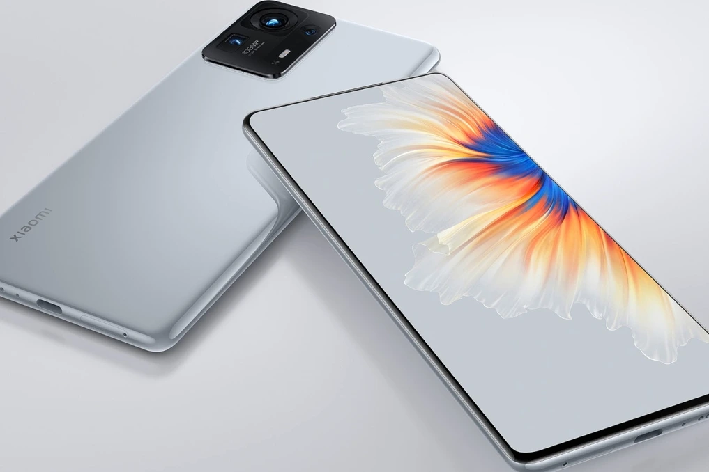 Smartphone Xiaomi MIX 5 vu de face, écran bord à bord avec caméra sous l’écran et lentille magnétique posée à côté