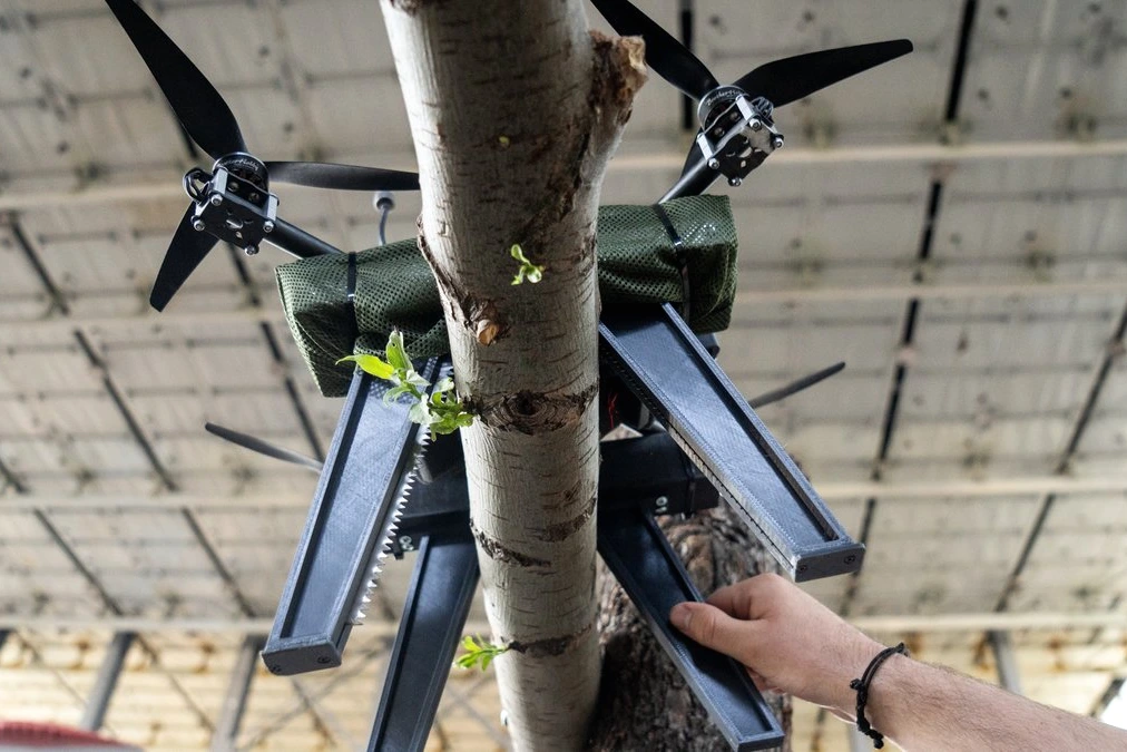 Soldat ukrainien testant un drone « à pattes » d’embuscade sur terrain boueux, près d’arbustes