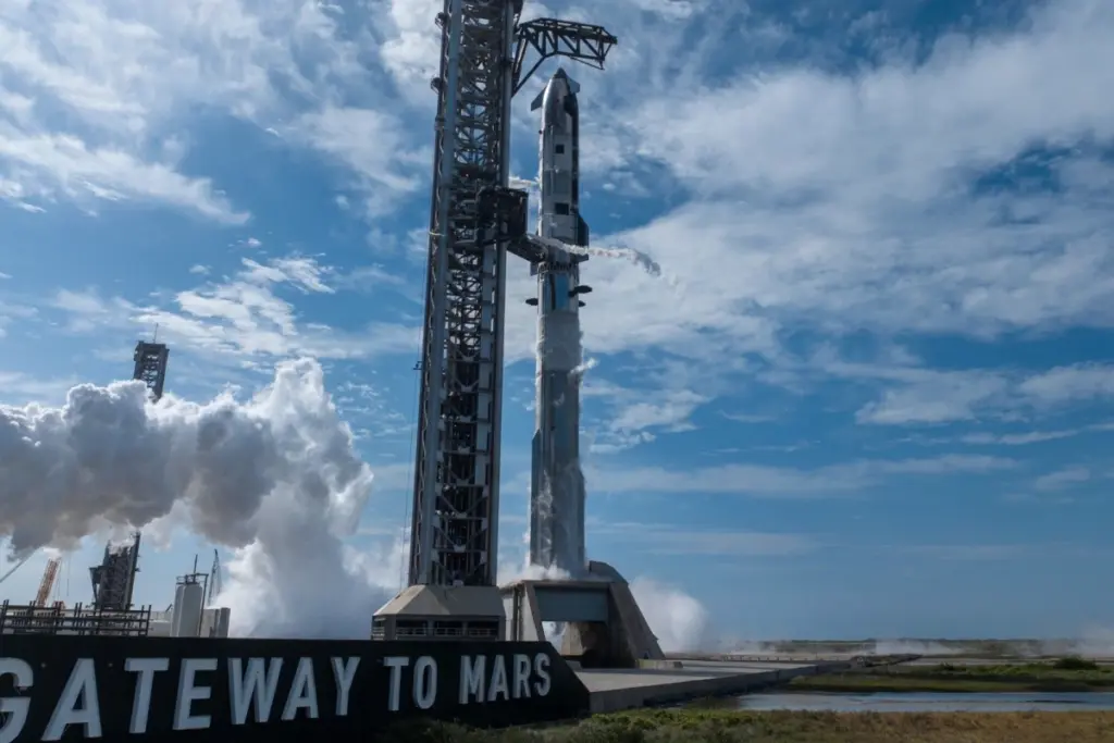 Starship V3 de SpaceX sur le pas de tir, fusée illuminée la nuit avec tour de lancement en arrière-plan