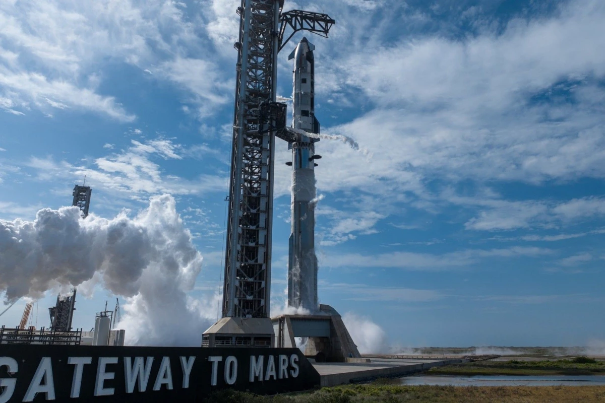 Starship V3 de SpaceX sur le pas de tir, fusée illuminée la nuit avec tour de lancement en arrière-plan