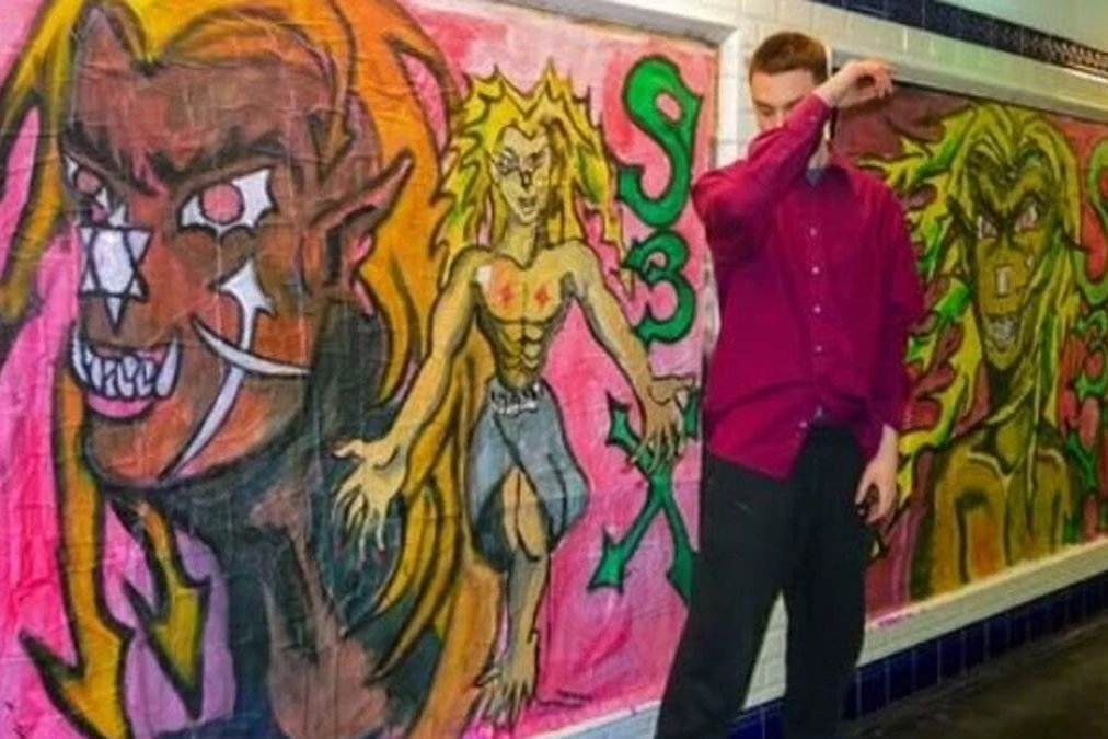 Street artiste dans le métro parisien, près d’une affiche accusée d’antisémitisme, voyageurs en arrière-plan