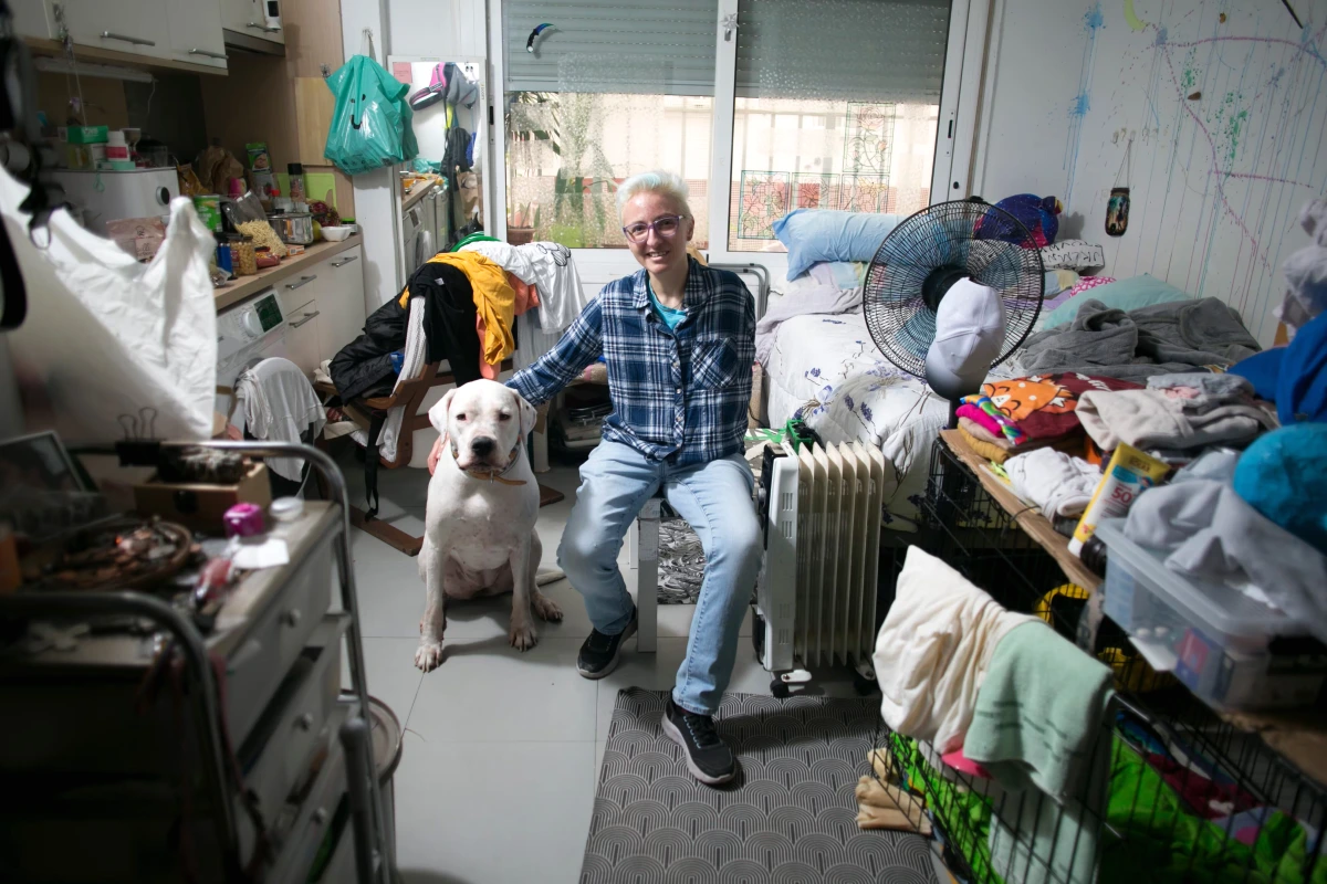 Surpopulation dans un appartement exigu : plusieurs personnes entassées autour d’un lit et de cartons