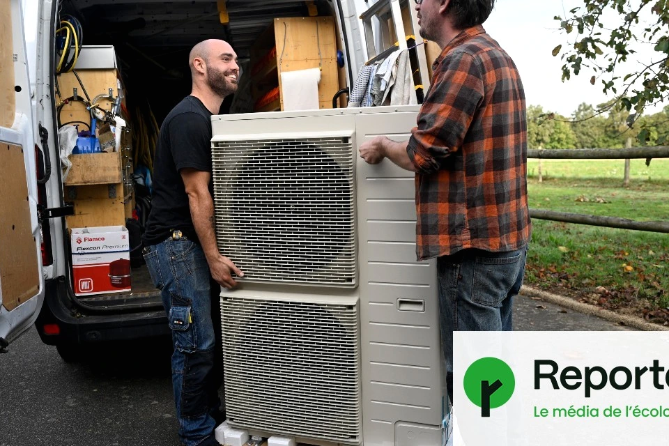 Technicien installant une pompe à chaleur extérieure près d’une maison, outils et unité visible