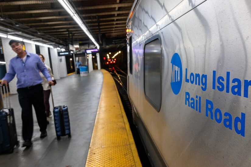Train du Long Island Rail Road à quai, quais vides et panneaux d’information indiquant un trafic à l’arrêt