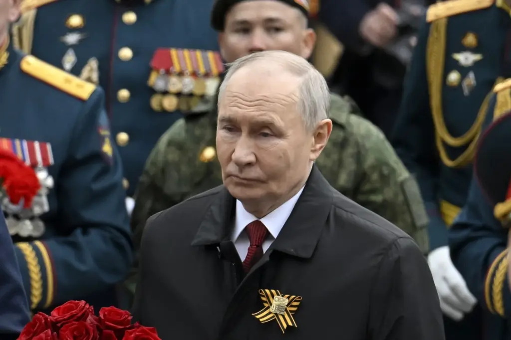 Vladimir Poutine au pupitre lors d’une allocution télévisée, drapeaux russes en arrière-plan.
