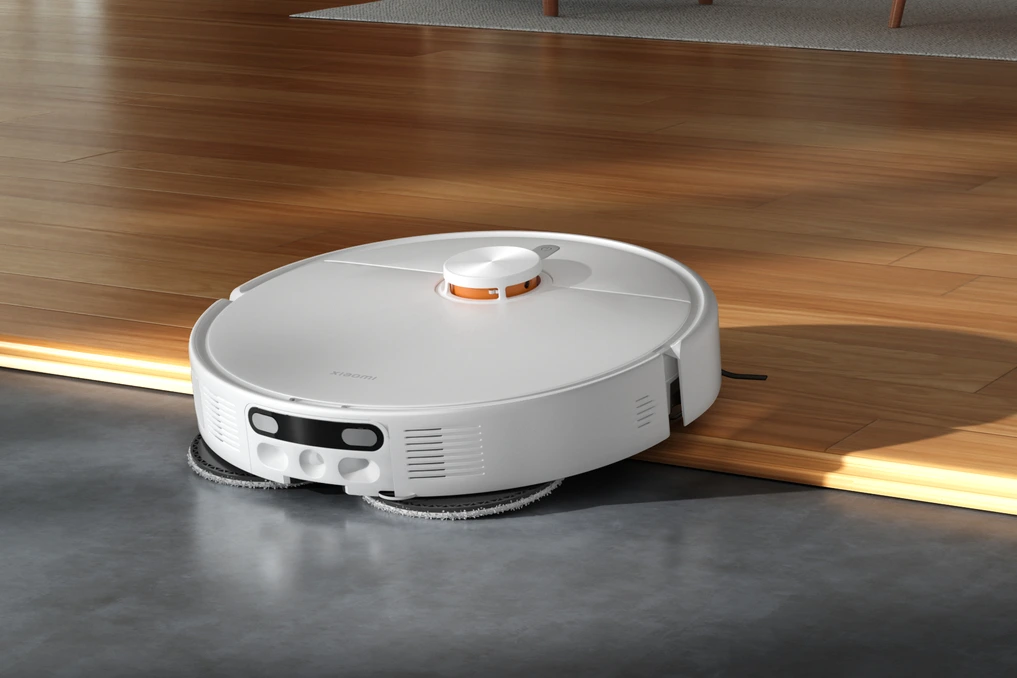 Xiaomi Robot Vacuum H50 noir posé au sol, avec station de charge compacte en arrière-plan