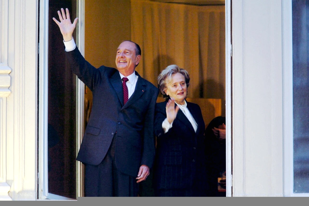 Bernadette Chirac souriante lors d’un événement officiel à Paris, en tenue élégante, devant un bâtiment historique