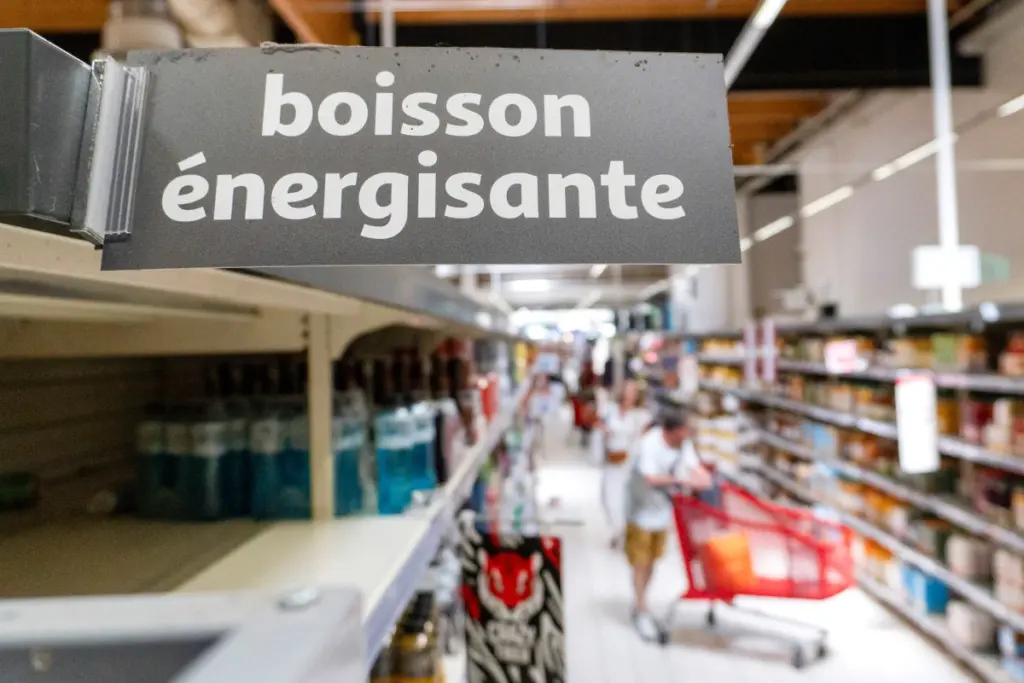 Canette Red Bull posée sur une table, avec documents et drapeau de l’Union européenne en arrière-plan