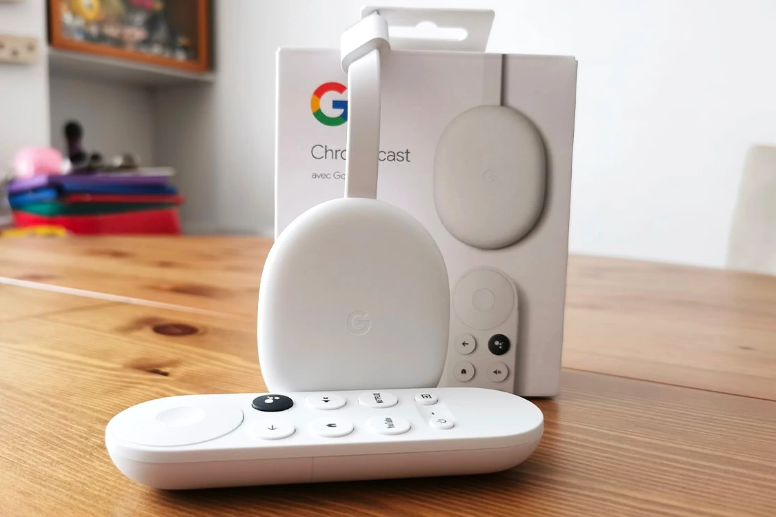 Chromecast branché à un téléviseur, écran de smartphone affichant les commandes sans télécommande.