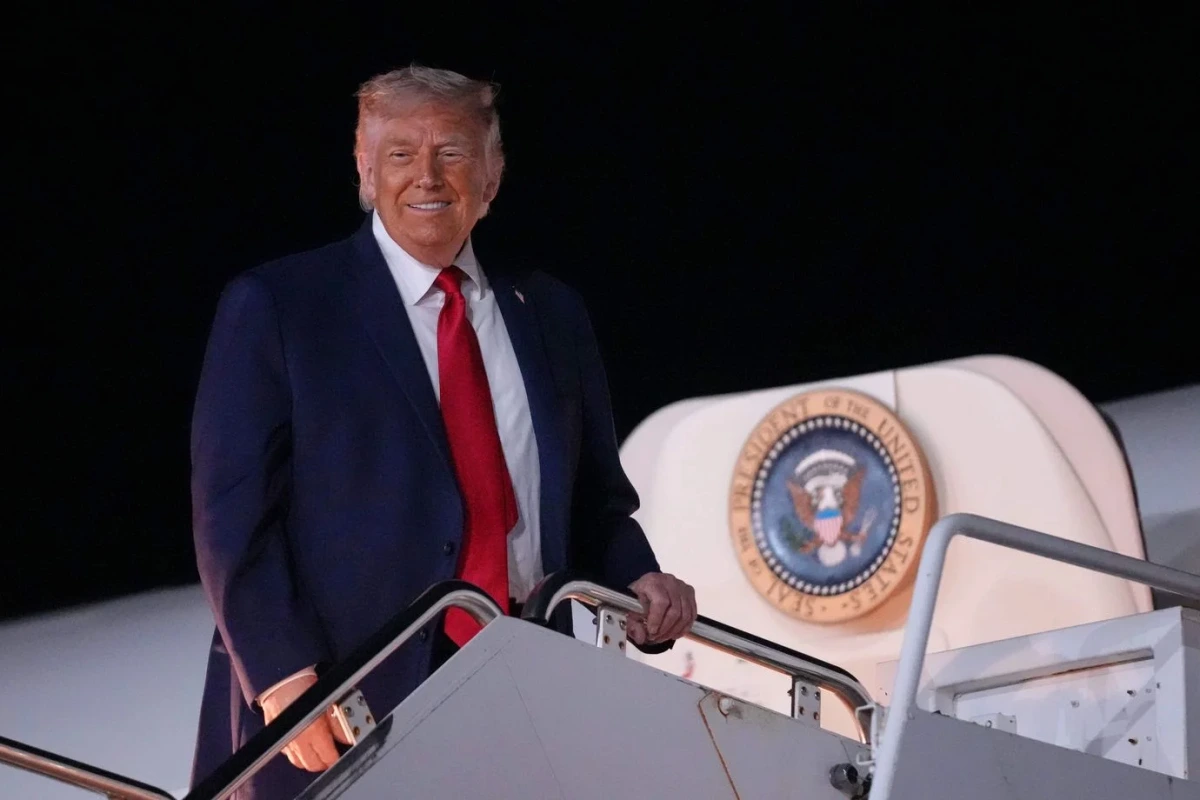 Donald Trump s’exprime devant des drapeaux américains, micro au pupitre, lors d’un meeting politique.