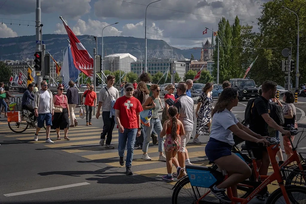 Drapeau suisse devant le Palais fédéral à Berne, illustrant le vote pour plafonner la population à 10 millions