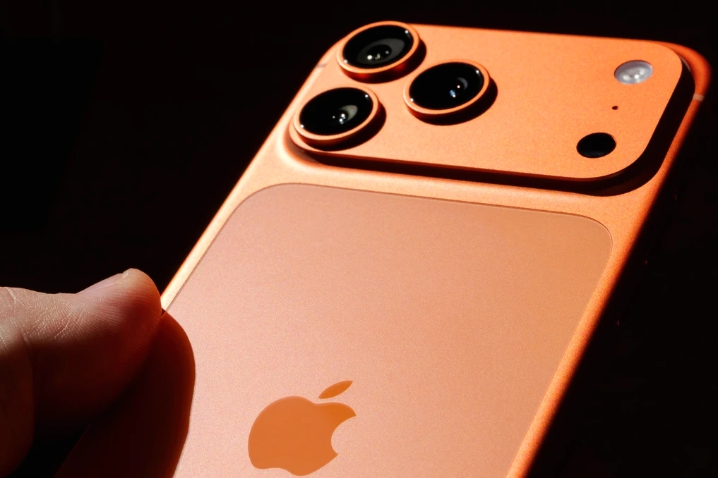 iPhone 18 Pro posé sur une table, écran allumé affichant une icône de batterie faible et un câble de charge à côté