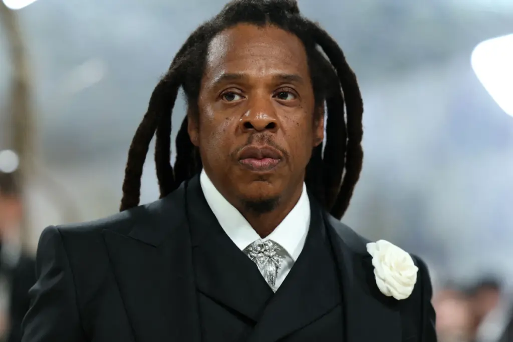 Jay-Z sur scène à Paris, micro en main, devant une foule de fans et des écrans lumineux