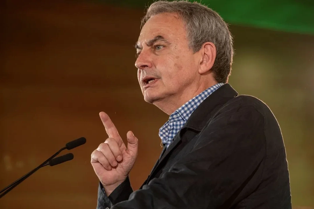 José Luis Zapatero devant un tribunal, en costume sombre, entouré de journalistes et de caméras