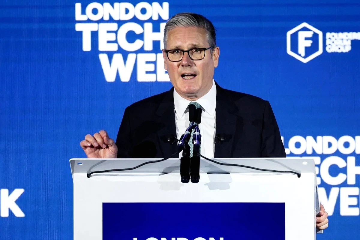 Keir Starmer devant des écrans affichant des logos de géants de la tech, lors d’une conférence de presse