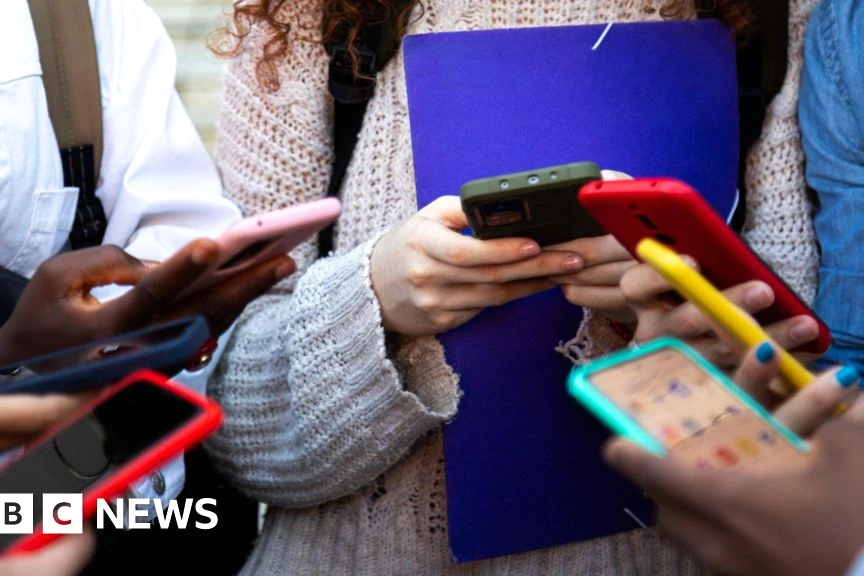 Keir Starmer devant des micros, avec un smartphone affichant des icônes de réseaux sociaux en arrière-plan.