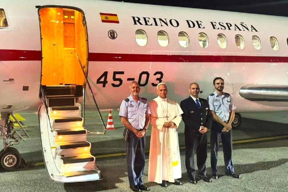 Le pape Léon XIV serre la main d’un membre d’équipage du Falcon, entouré de personnel en uniforme.