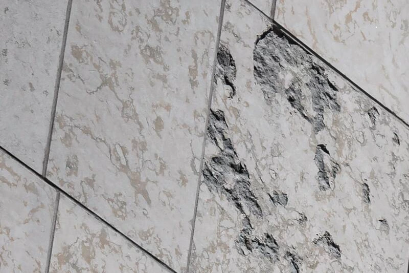 Logo de Desjardins sur la façade d’une succursale, avec des passants flous au premier plan