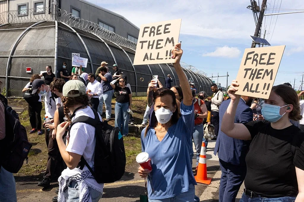 Manifestants et policiers devant un centre de détention du New Jersey, avec arrestations et pancartes visibles