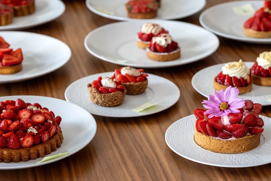 Part de tarte aux fraises à Paris, fraises fraîches sur crème pâtissière, sur assiette blanche.