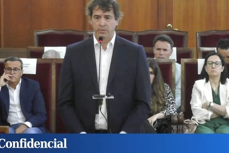 Pedro Sánchez en costume, visage sérieux, devant des drapeaux espagnol et européen, en extérieur.