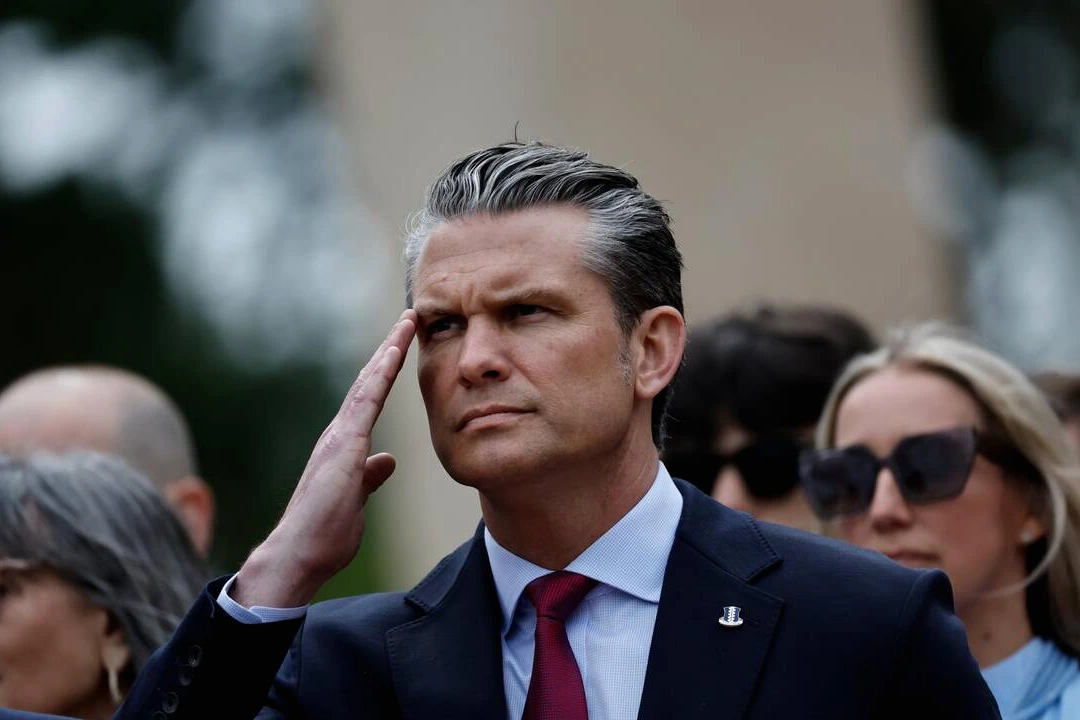 Pete Hegseth parlant devant des drapeaux, évoquant une « invasion » d’immigrés en France