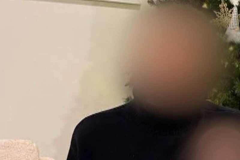 Pile de billets et chèque symbolique « 100 000 $ » devant la photo d’une famille endeuillée