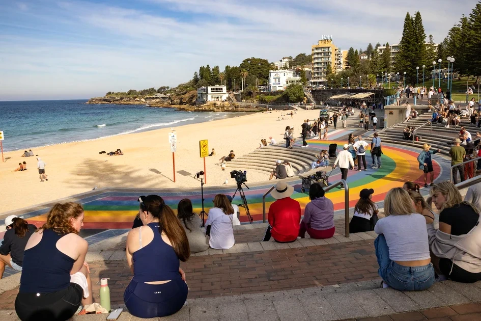 Plage de Sydney avec une femme blessée par un requin, secouristes et baigneurs rassemblés près de l’eau