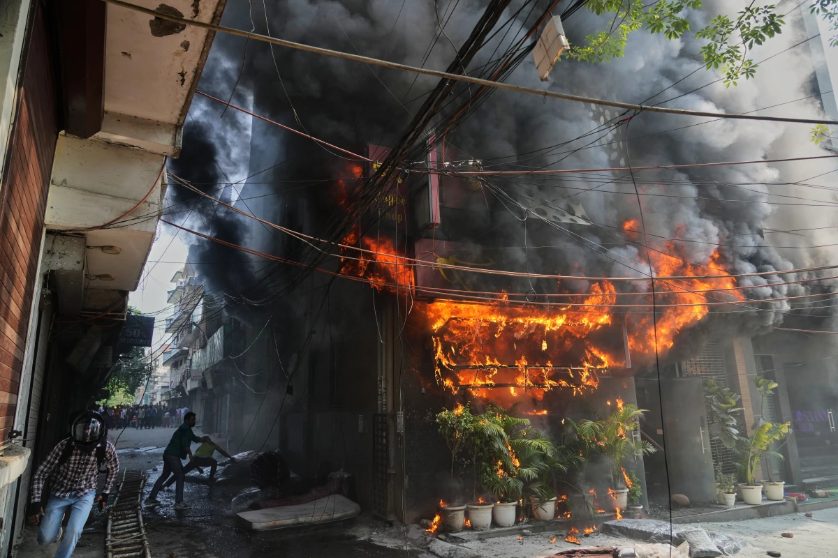 Pompiers devant un hôtel à New Delhi en flammes, fumée épaisse et véhicules d’urgence sur place
