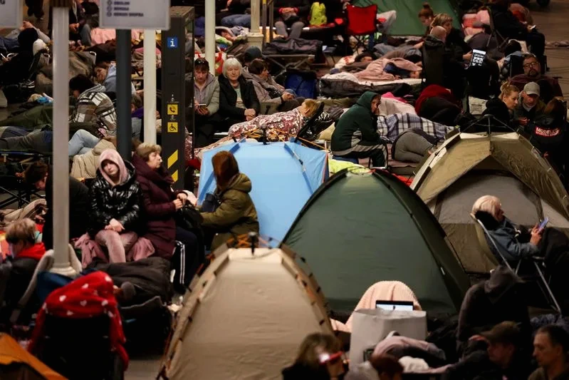 Secouristes près d’un immeuble détruit en Ukraine après une attaque russe, décombres et fumée au sol
