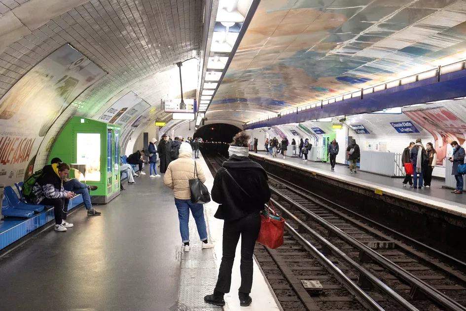 Supporters du PSG devant une station de métro parisienne fermée, grilles baissées et panneaux d’information visibles