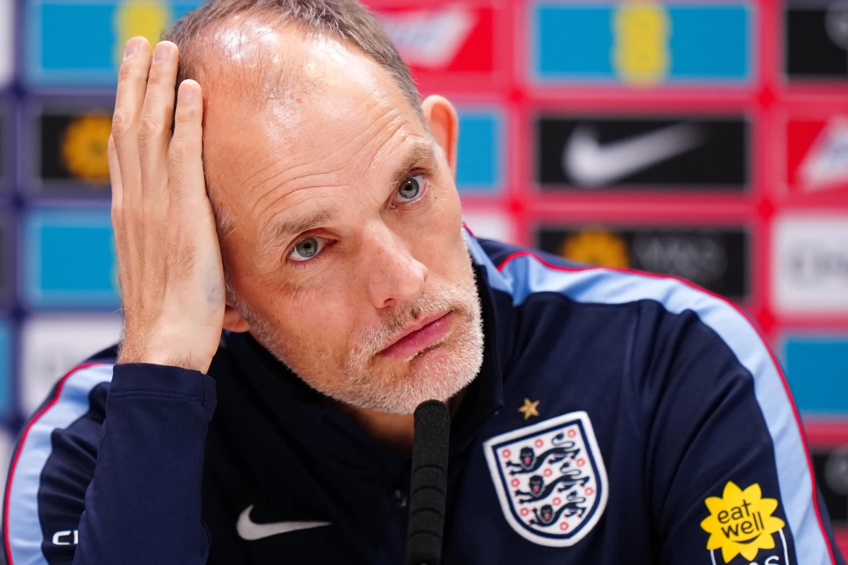 Thomas Tuchel et des joueurs de l’Angleterre sur le banc, regard préoccupé pendant un match.