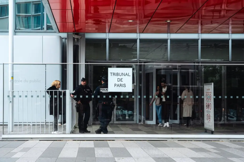 Un informaticien au tribunal de Paris, visage flouté, devant des écrans affichant des deepfakes sexuels