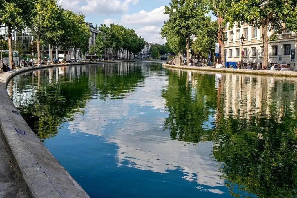 Vue de Paris au coucher du soleil, passants sur une place animée près d’un café en terrasse